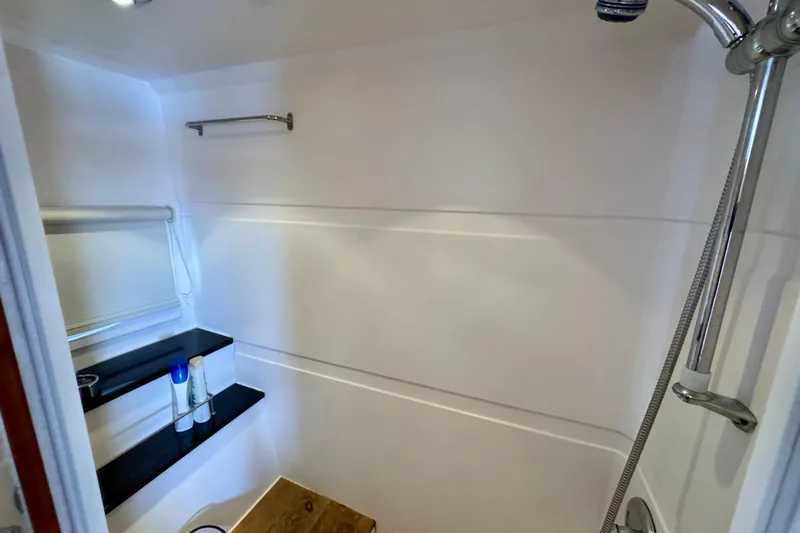 Makin' Waves II Yacht Photos Pics Shower area in 2011 Regal 52 Sport Coupe yacht with shelves and chrome fixtures.