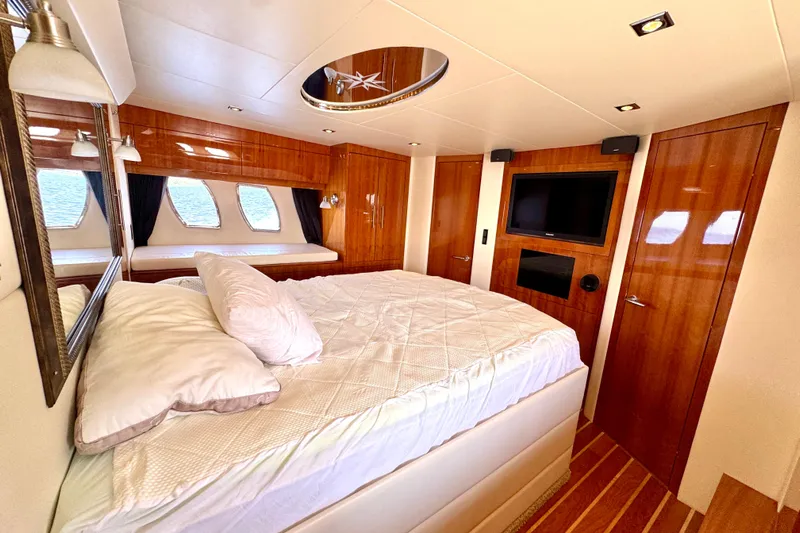 Makin' Waves II Yacht Photos Pics Luxurious bedroom interior of 2011 Regal 52 Sport Coupe yacht with wood accents and modern amenities.
