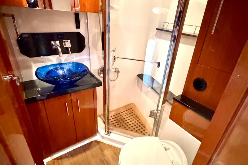 Makin' Waves II Yacht Photos Pics Luxurious bathroom in 2011 Regal 52 Sport Coupe with glass sink and modern shower.