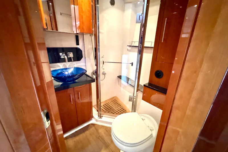 Makin' Waves II Yacht Photos Pics Luxurious bathroom in 2011 Regal 52 Sport Coupe yacht with modern fixtures and wooden cabinetry.