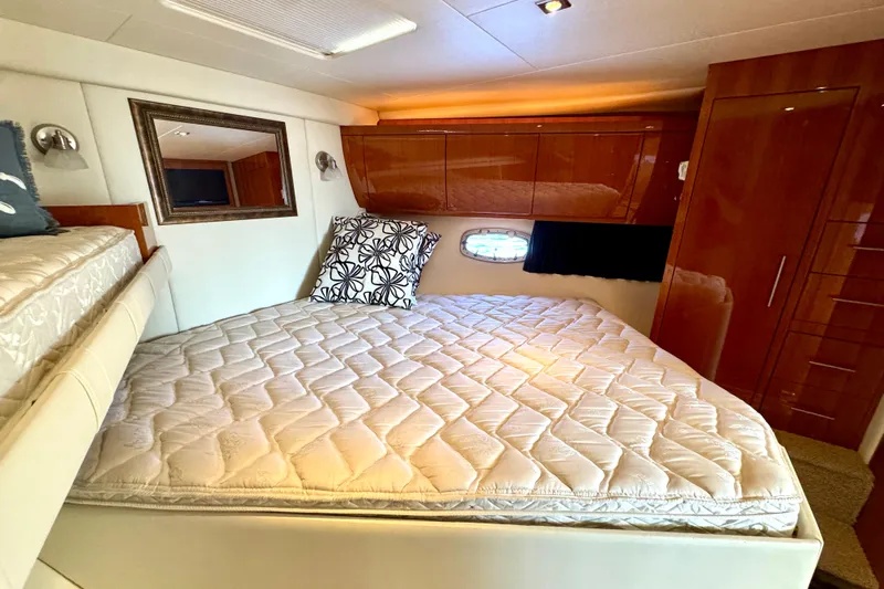 Makin' Waves II Yacht Photos Pics Luxurious cabin interior of 2011 Regal 52 Sport Coupe with cozy bed and elegant wood finishes.