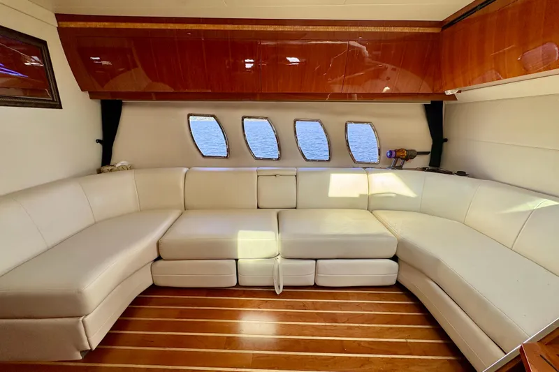 Makin' Waves II Yacht Photos Pics Luxurious interior of 2011 Regal 52 Sport Coupe with white leather seating and wooden flooring.