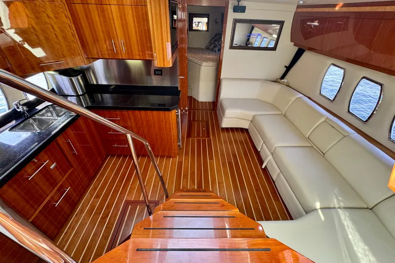 Makin' Waves II Yacht Photos Pics Luxurious interior of 2011 Regal 52 Sport Coupe with wood flooring and white leather seating.