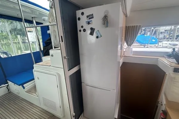 Halldis Yacht Photos Pics Interior of 2011 Lagoon 400 yacht with fridge and blue seating area.
