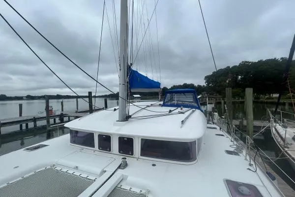 Halldis Yacht Photos Pics 2011 Lagoon 400 catamaran docked, featuring a blue sail and overcast sky.