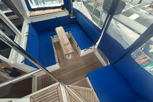 Halldis Yacht Photos Pics 2011 Lagoon 400 yacht cockpit with blue seating and wooden flooring.