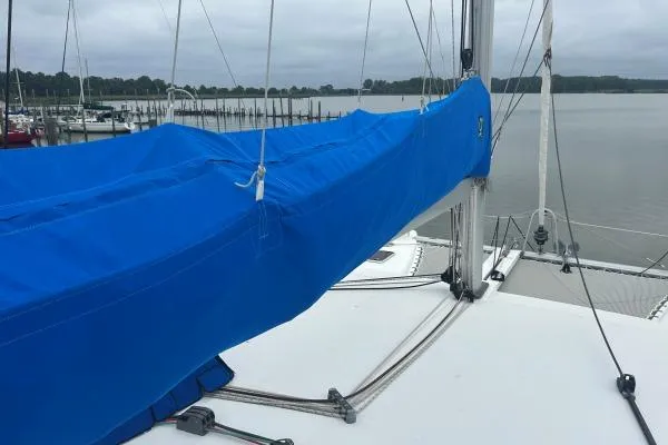 Halldis Yacht Photos Pics 2011 Lagoon 400 sailboat with blue sail cover docked by a calm lake.