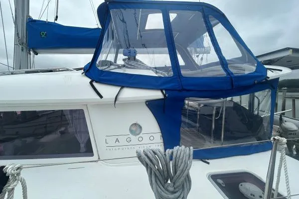 Halldis Yacht Photos Pics 2011 Lagoon 400 catamaran with blue canopy and ropes, docked in a marina.