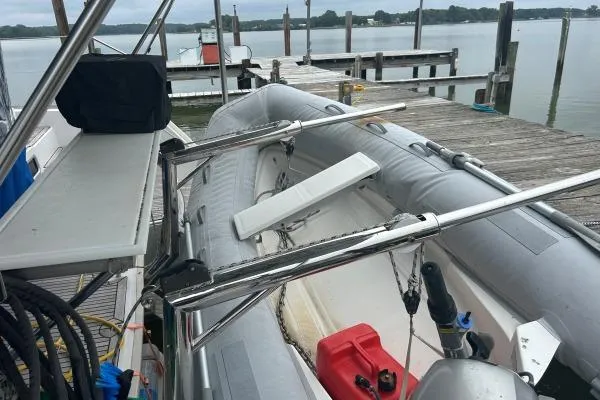 Halldis Yacht Photos Pics Inflatable boat docked beside a Lagoon 400 catamaran, 2011 model, at a wooden pier.