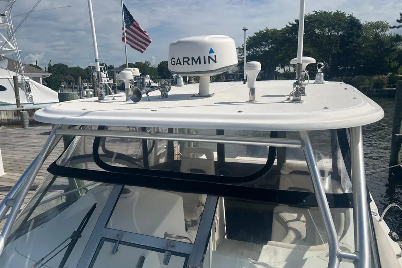  Yacht Photos Pics 2004 Boston Whaler 305 Conquest with Garmin radar, docked near American flag.