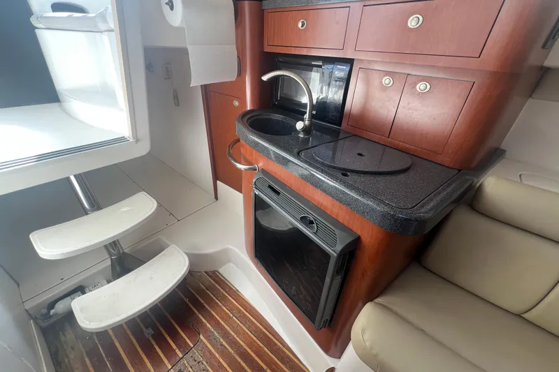  Yacht Photos Pics 2004 Boston Whaler 305 Conquest cabin interior with kitchenette and seating area.