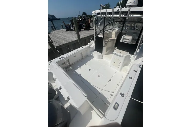  Yacht Photos Pics 2004 Boston Whaler 305 Conquest boat docked, showcasing spacious deck and seating area.