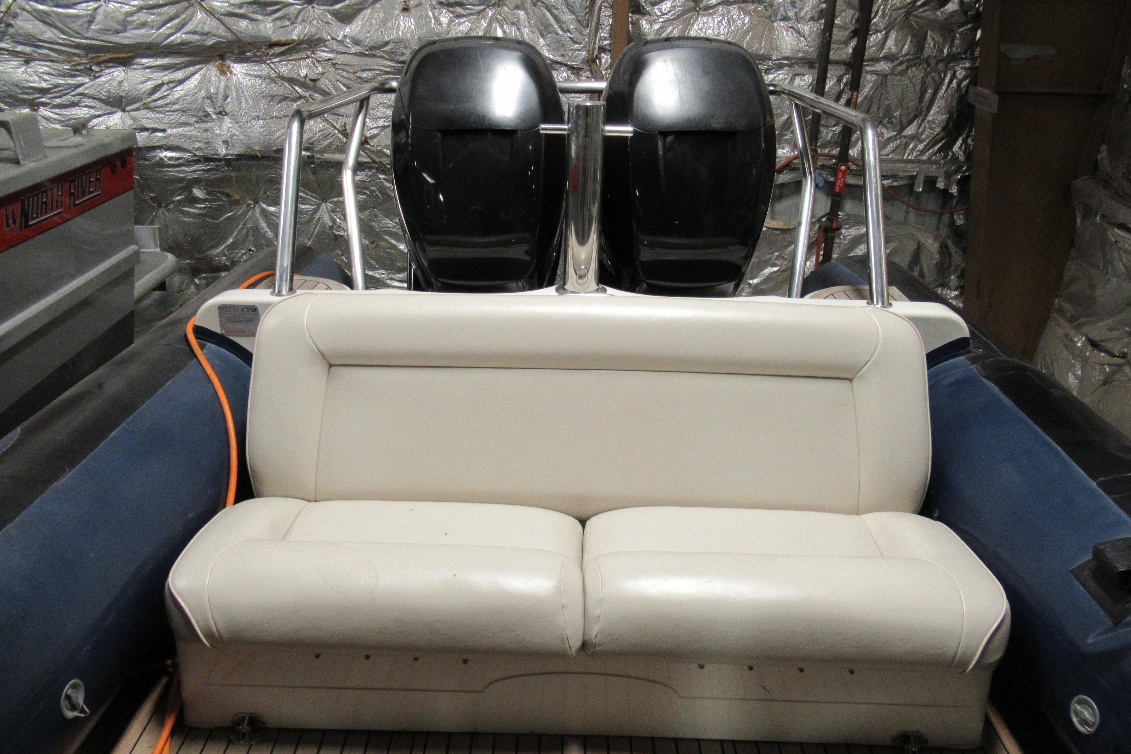 2007 Protector Targa 28 boat interior with white seating and dual engines.