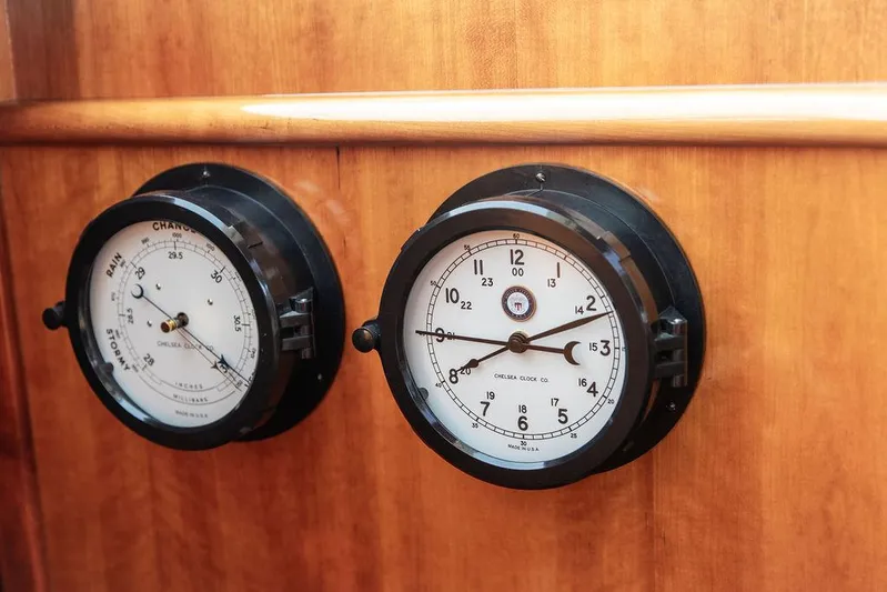 Kite Yacht Photos Pics Nautical instruments on 2014 Hinckley Talaria 43, featuring a clock and barometer on wooden panel.