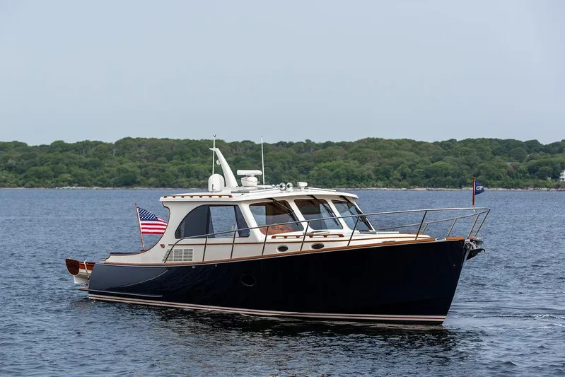 Kite Yacht Photos Pics 2014 Hinckley Talaria 43 yacht cruising on calm waters with lush green shoreline.