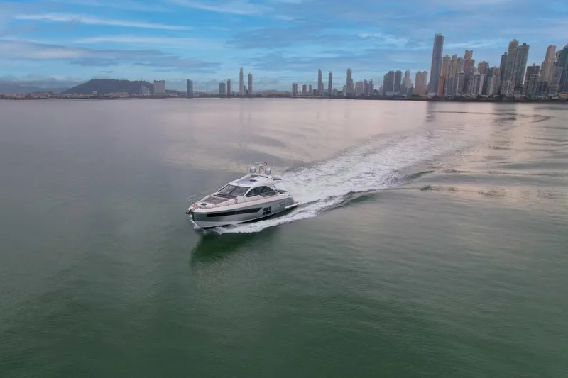  Yacht Photos Pics 2019 Azimut S6 yacht cruising near a city skyline under a blue sky.