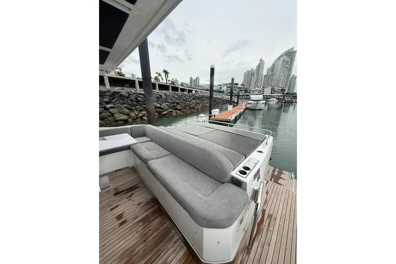  Yacht Photos Pics 2019 Azimut S6 yacht with gray seating, docked in a marina with city skyline.