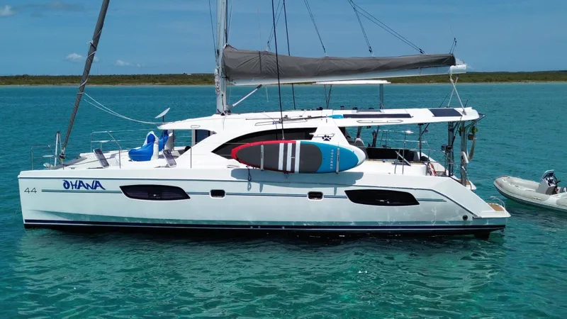  Yacht Photos Pics 2016 Leopard 44 catamaran with paddleboards, anchored in clear turquoise water.