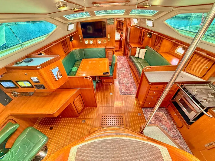 Bluepearl Yacht Photos Pics Luxurious 2006 Passport Vista 515CC yacht interior with wood finish and green seating.