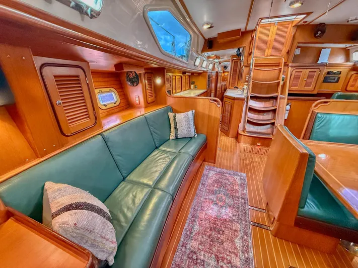 Bluepearl Yacht Photos Pics Luxurious interior of 2006 Passport Vista 515CC yacht with wooden finishes and green seating.