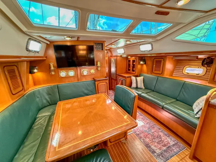 Bluepearl Yacht Photos Pics Luxurious interior of 2006 Passport Vista 515CC yacht with wood finishes and green seating.