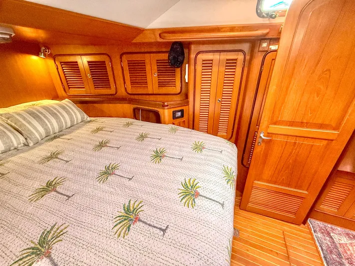 Bluepearl Yacht Photos Pics Cozy cabin interior of 2006 Passport Vista 515CC yacht with wooden finishes and palm-patterned bedding.