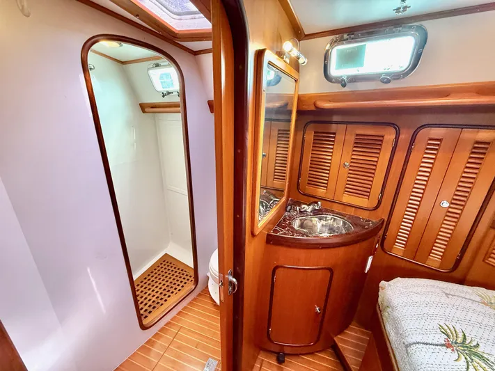 Bluepearl Yacht Photos Pics Luxurious 2006 Passport Vista 515CC yacht interior with wooden cabinetry and compact bathroom.