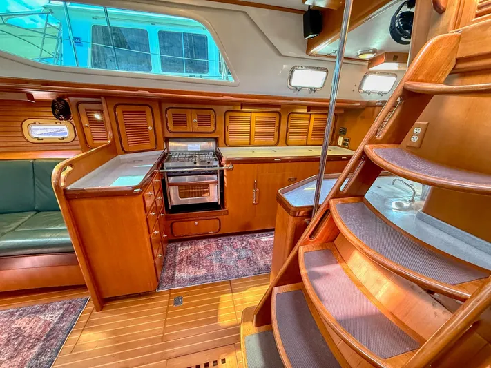 Bluepearl Yacht Photos Pics Luxurious 2006 Passport Vista 515CC yacht interior with wooden cabinetry and staircase.
