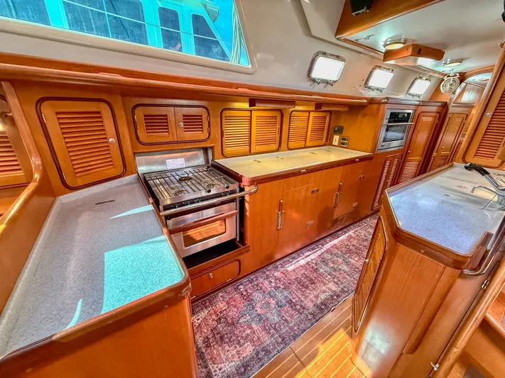 Bluepearl Yacht Photos Pics Luxurious 2006 Passport Vista 515CC yacht kitchen with wood cabinetry and modern appliances.