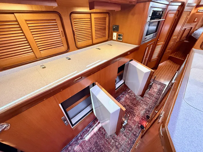 Bluepearl Yacht Photos Pics Interior of 2006 Passport Vista 515CC yacht with wooden cabinetry and open storage compartments.