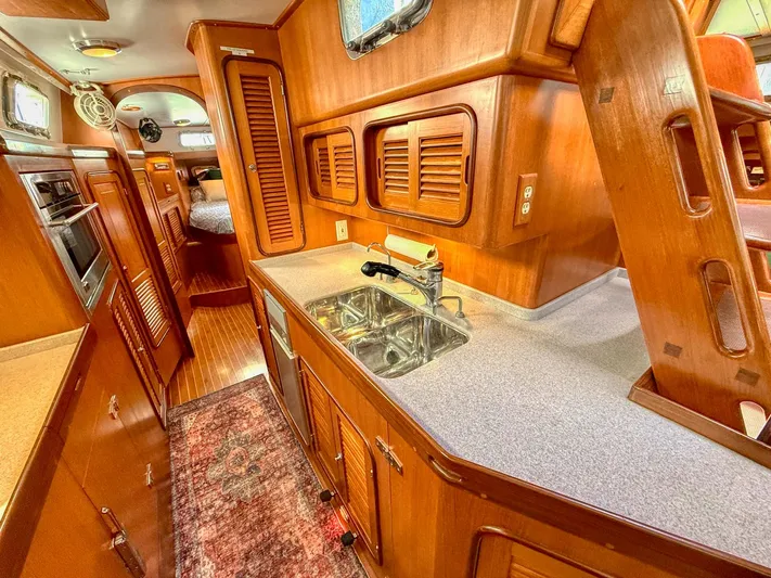 Bluepearl Yacht Photos Pics Interior of 2006 Passport Vista 515CC yacht, featuring a wooden kitchen with sink and appliances.