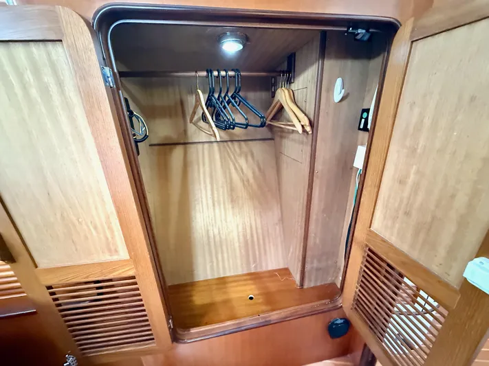 Bluepearl Yacht Photos Pics Wooden closet interior with hangers in a 2006 Passport Vista 515CC yacht.