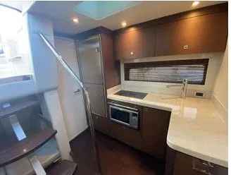 Slipknot Yacht Photos Pics Interior of 2012 Sea Ray 410 Sundancer yacht, featuring modern kitchen with wood cabinetry.