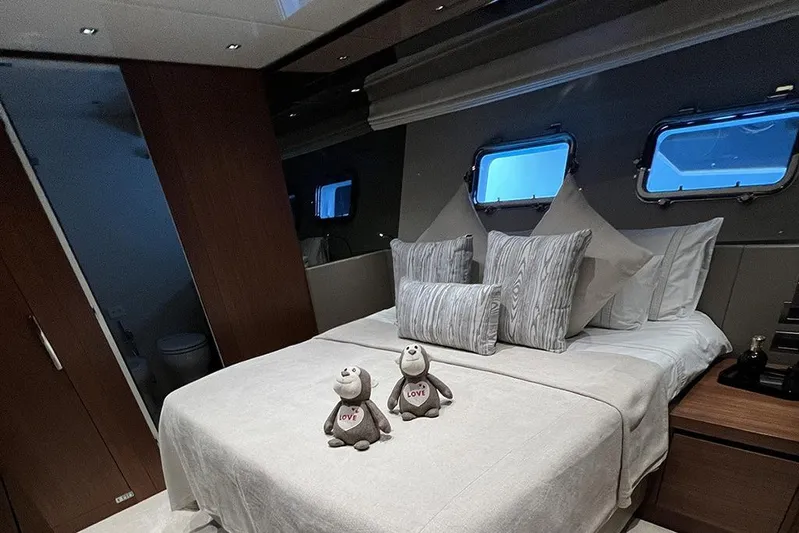  Yacht Photos Pics Luxurious bedroom interior of 2019 Sanlorenzo 86 yacht with plush bedding and porthole windows.