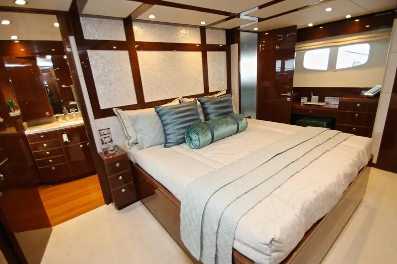 Quit Sun Yacht Photos Pics Luxurious bedroom interior on 2015 Hargrave 76 yacht, featuring elegant wood finishes and plush bedding.