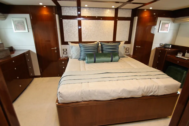 Quit Sun Yacht Photos Pics Luxurious bedroom interior on 2015 Hargrave 76 yacht, featuring elegant wood finishes and plush bedding.