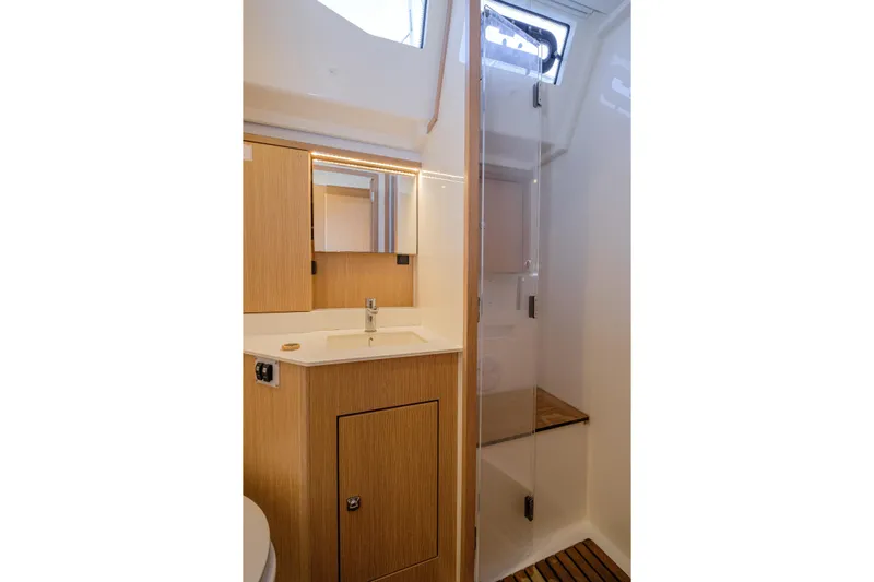  Yacht Photos Pics Modern bathroom interior of 2022 Bavaria C57 yacht with wood accents and glass shower.
