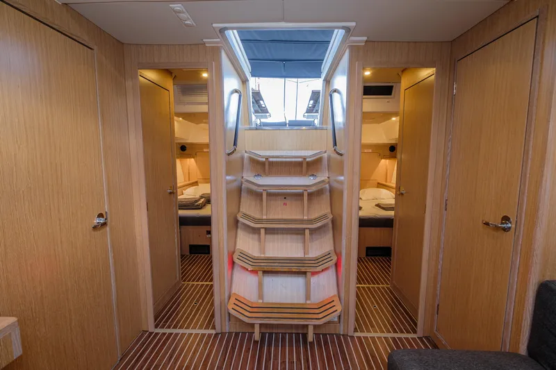  Yacht Photos Pics Interior of 2022 Bavaria C57 yacht with wooden stairs and cozy cabins.