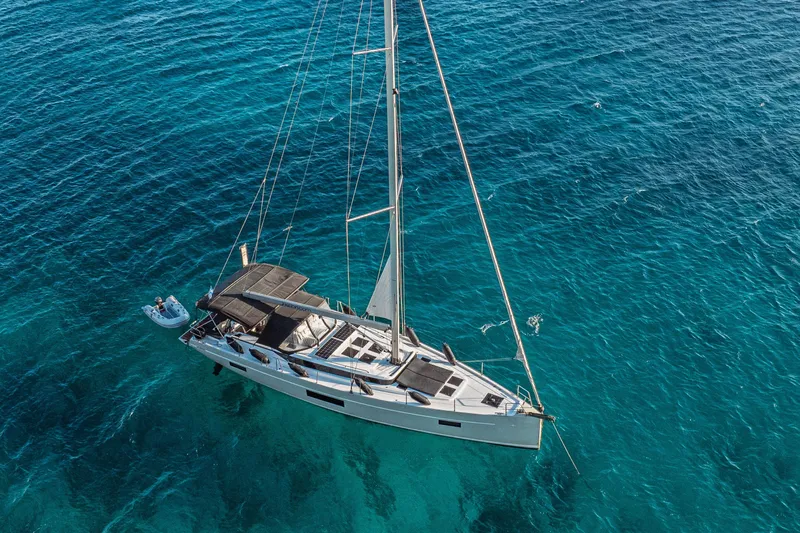  Yacht Photos Pics Aerial view of 2022 Bavaria C57 yacht sailing on clear blue ocean waters.