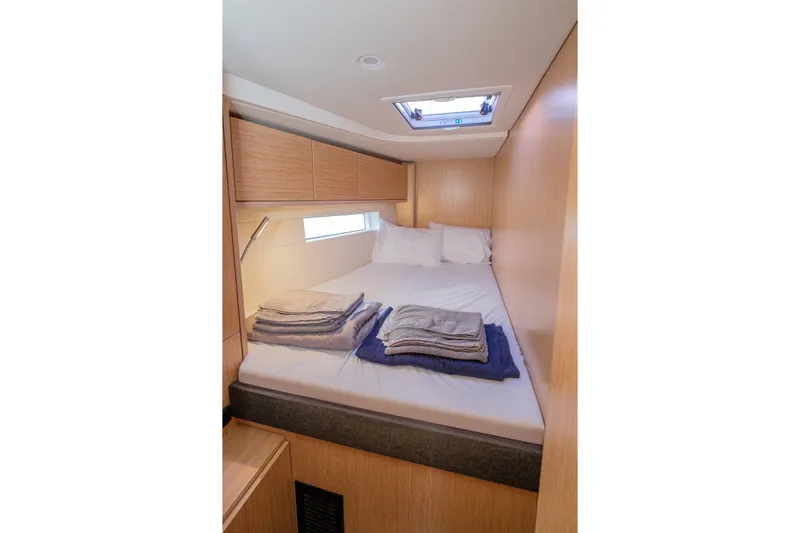  Yacht Photos Pics Cozy cabin interior of 2022 Bavaria C57 yacht with neatly arranged bedding.