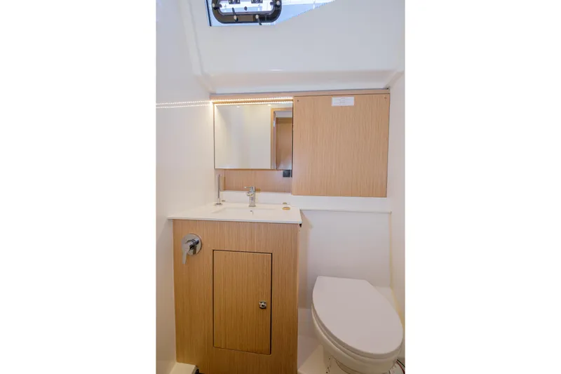  Yacht Photos Pics Modern bathroom interior of 2022 Bavaria C57 yacht with wooden cabinetry and sleek fixtures.