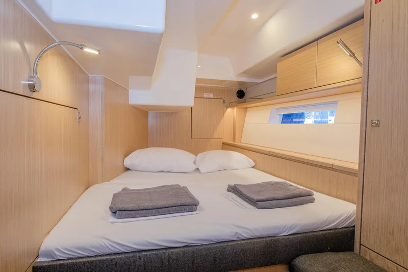  Yacht Photos Pics Luxurious cabin interior of 2022 Bavaria C57 yacht with cozy bed and modern lighting.