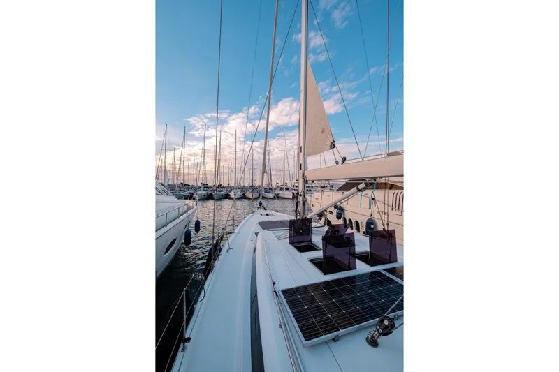  Yacht Photos Pics Sailing yacht Bavaria C57, 2022 model, docked in a marina under a clear blue sky.