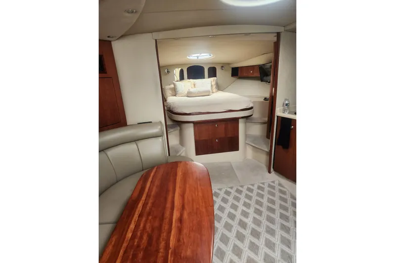 Bella Vita Yacht Photos Pics Luxurious interior of 2002 Cruisers Yachts 3870 Express with cozy bed and elegant wood finishes.
