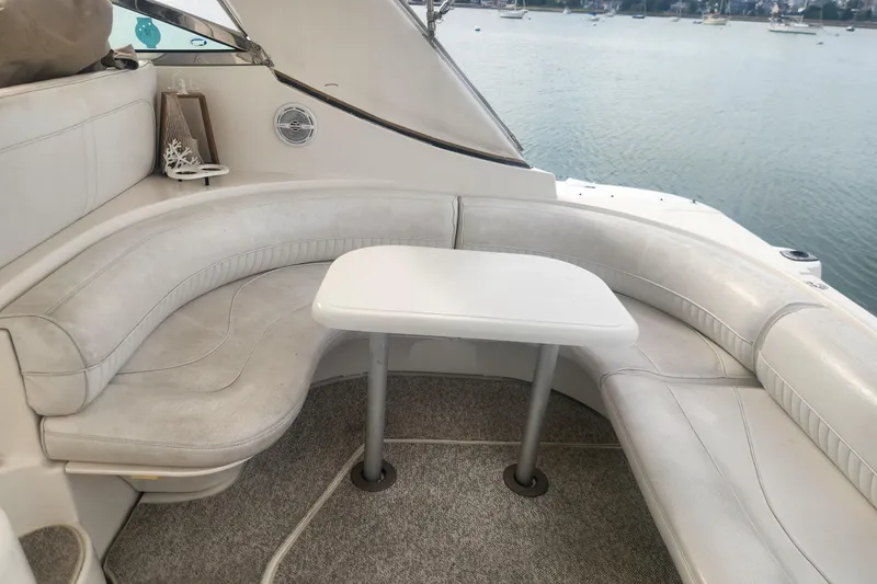 Bella Vita Yacht Photos Pics 2002 Cruisers Yachts 3870 Express interior with white seating and table, overlooking water.