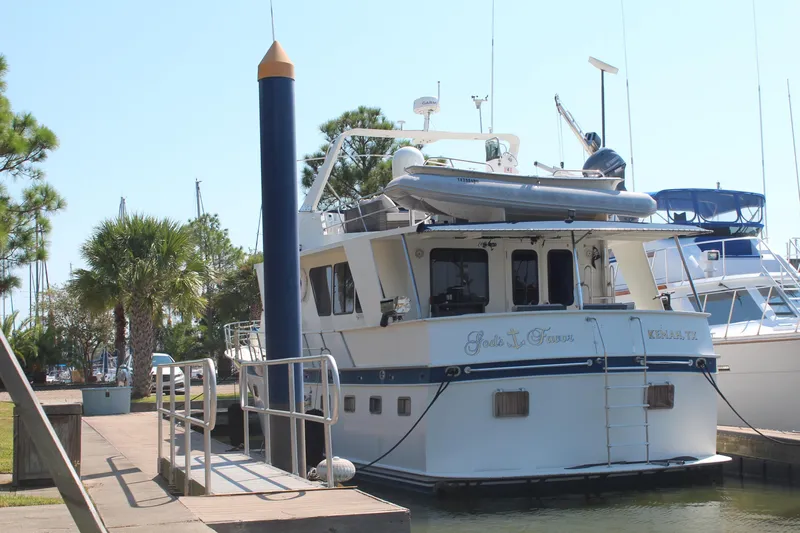 Gods Favor Yacht Photos Pics 1986 DeFever 53 yacht docked at marina with palm trees and clear sky.