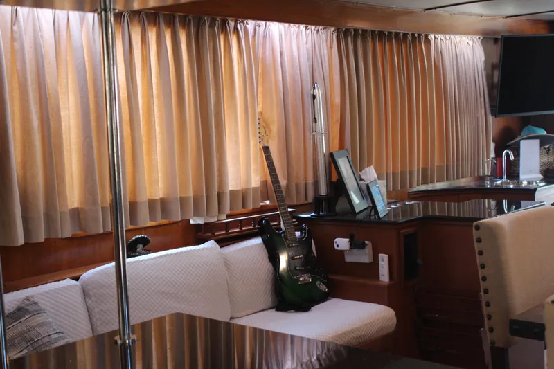 Gods Favor Yacht Photos Pics Interior of 1986 DeFever 53 yacht with guitar, sofa, and curtains.