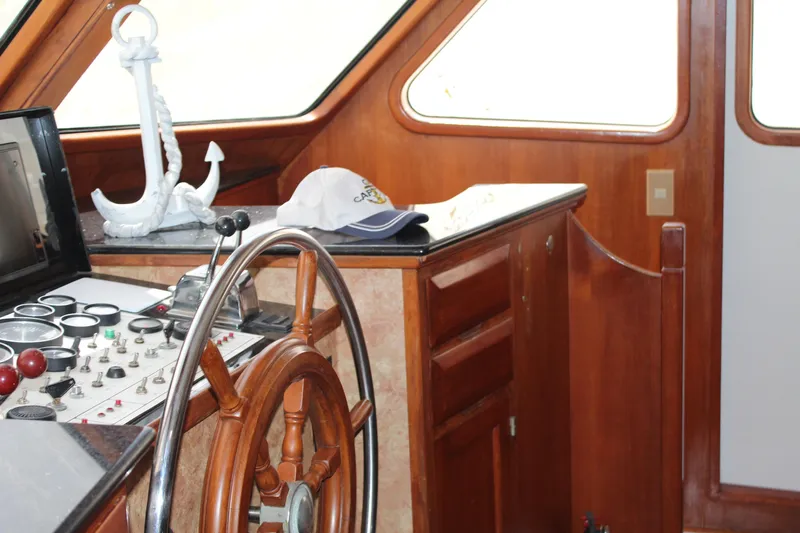 Gods Favor Yacht Photos Pics 1986 DeFever 53 yacht helm with wooden wheel, control panel, and nautical decor.