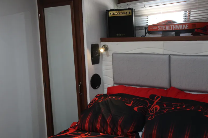Gods Favor Yacht Photos Pics Bedroom interior of 1986 DeFever 53 yacht with musical-themed bedding and amplifier.