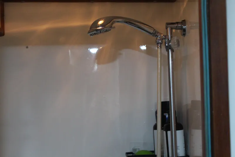 Gods Favor Yacht Photos Pics Shower area inside a 1986 DeFever 53 yacht, featuring a chrome showerhead.